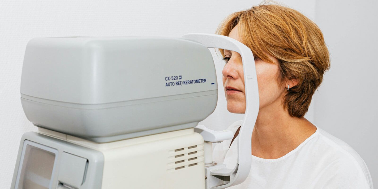 A woman is undergoing automatic optometry