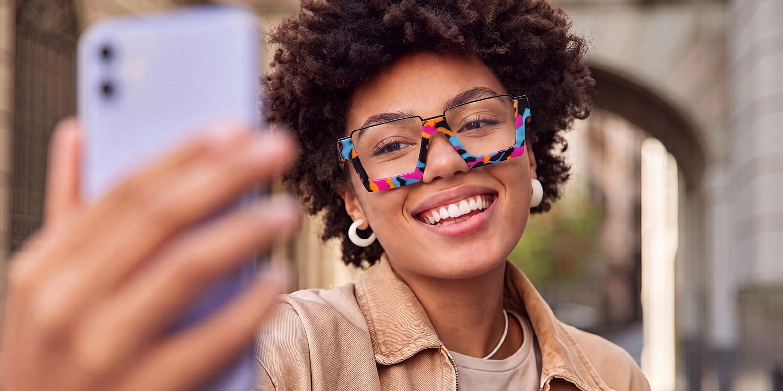 Pretty lady tries on clear glasses by uploading her photo on a mobile app
