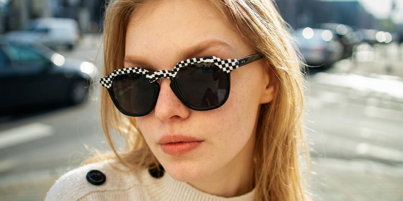 a blonde hair woman wearing geometric sunglasses