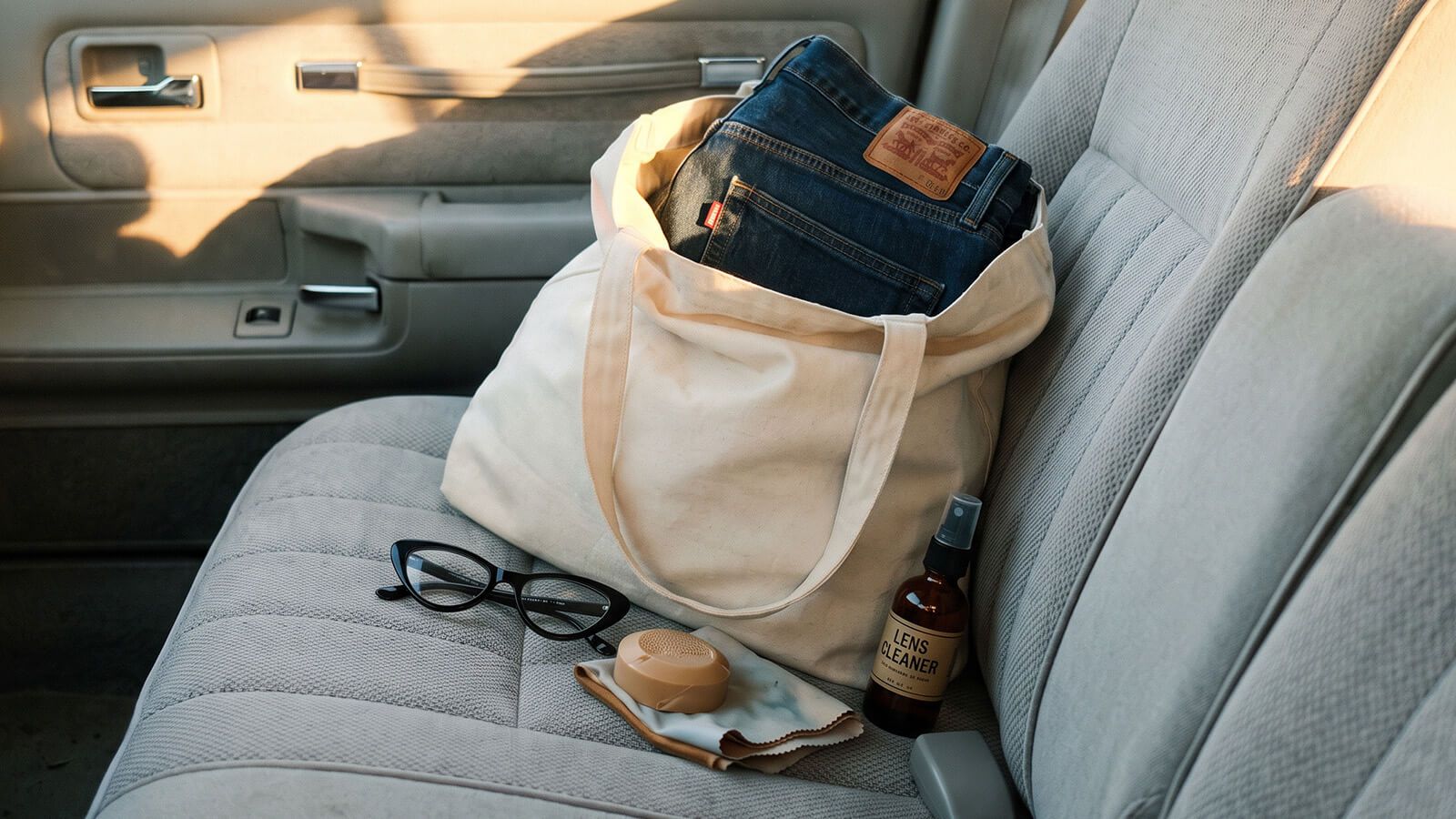commute bag with glasses, solid perfume and a lens cleaner spray