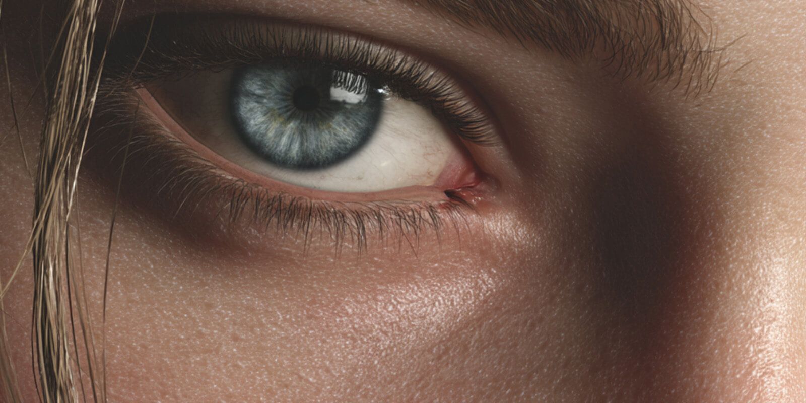 Partial close-up of female face with grey eyes